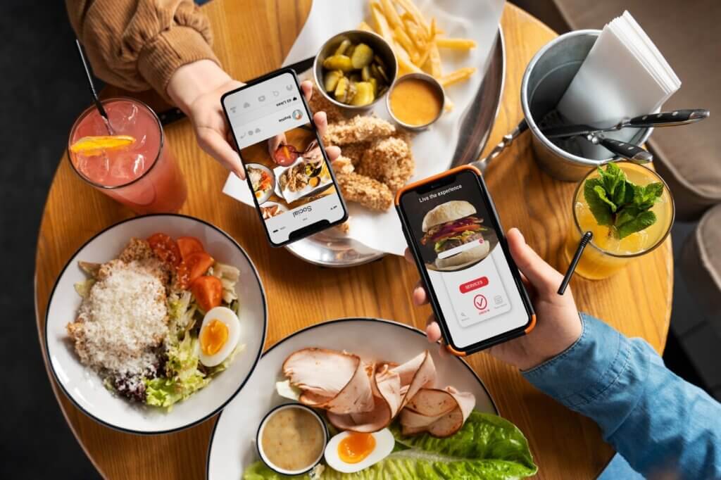 Deux personnes utilisant des applications de restaurant sur leurs smartphones, illustrant la création No Code.